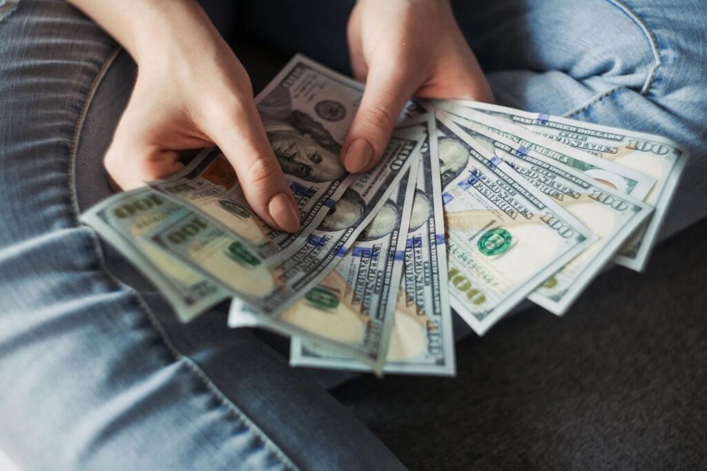 a housing resident holds cash in their hand